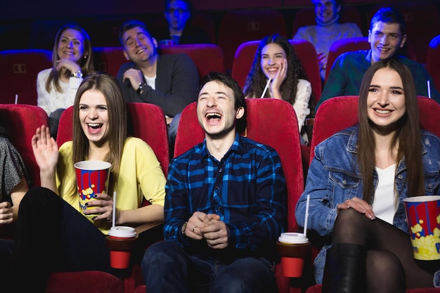 Los amigos de un chico y una chica se ríen a carcajadas en un cine