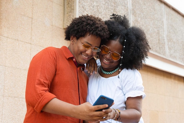 Amigos en la ciudad usando teléfono celular