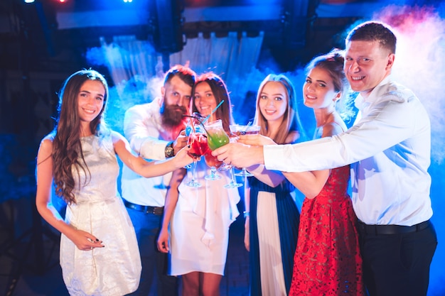 Amigos con cócteles bebidas en una fiesta.