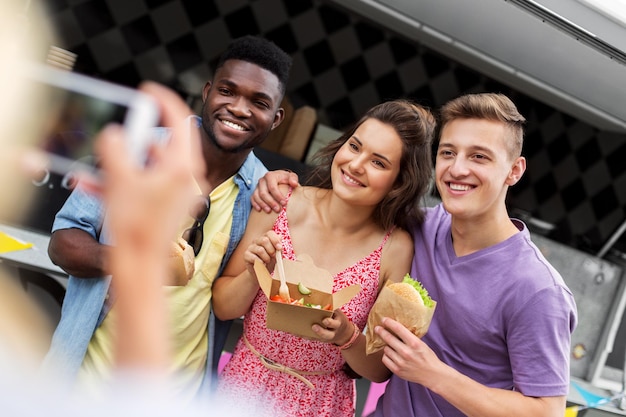 amigos com comida para levar fotografando ao ar livre