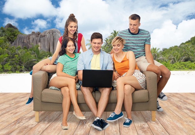 amigos com laptop sobre a praia da ilha de Seychelles