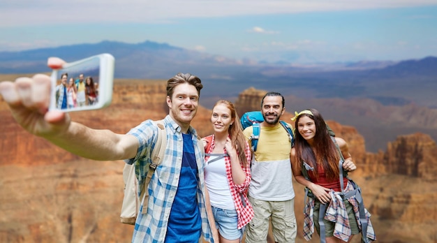 amigos com mochila tirando selfie por smartphone