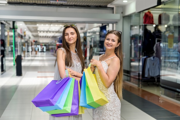 Amigos com sacolas de compras descansando no sofá no shopping