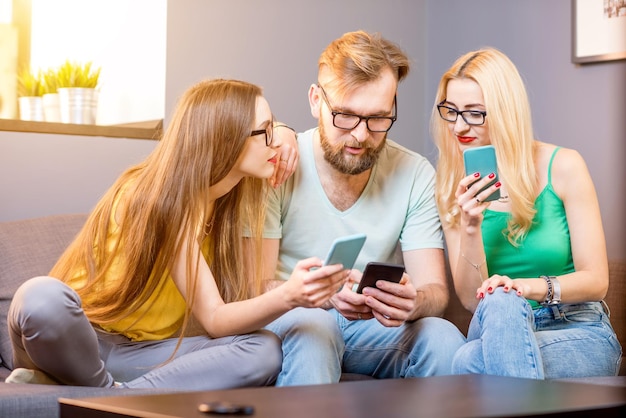 Amigos com telefones em casa