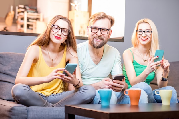 Amigos com telefones em casa