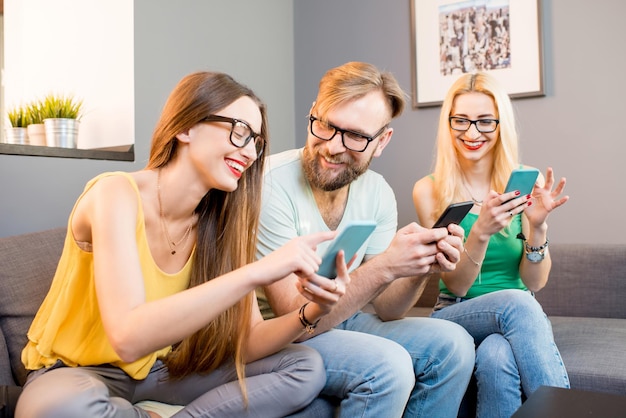 Amigos com telefones em casa