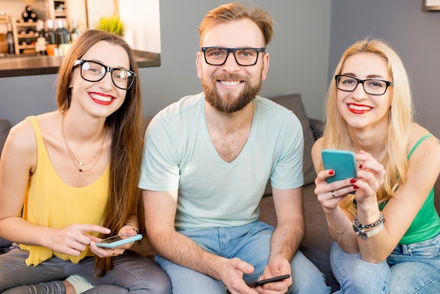 Amigos com telefones em casa