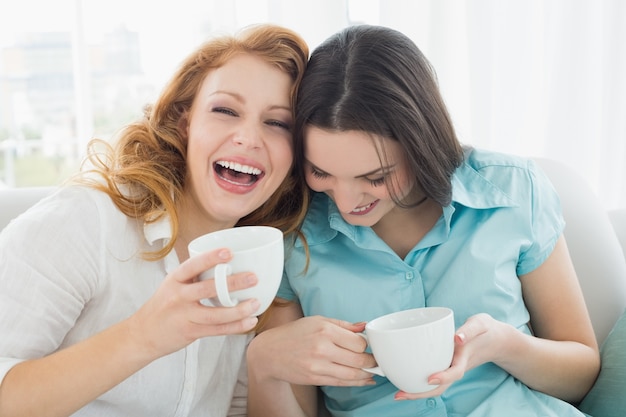 Amigos com xícaras de café desfrutando de uma conversa em casa