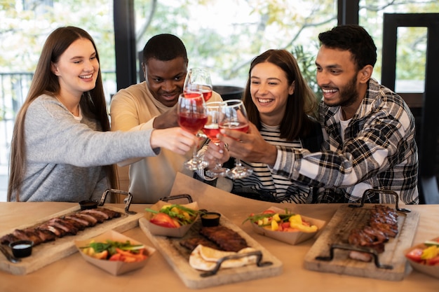 Foto amigos comemorando e segurando bebidas em uma reunião