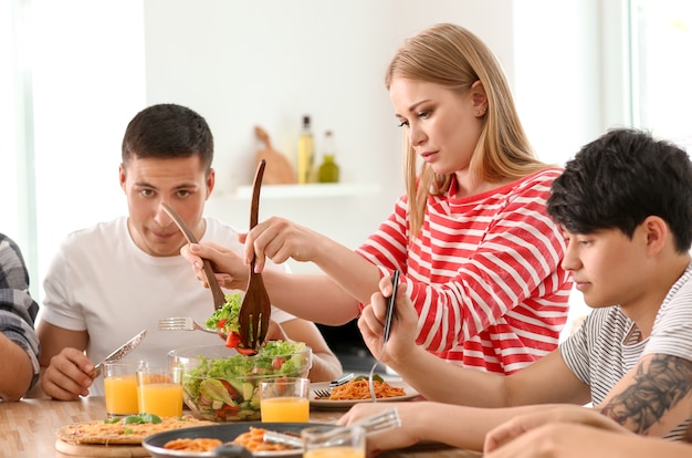 Amigos comendo na mesa da cozinha