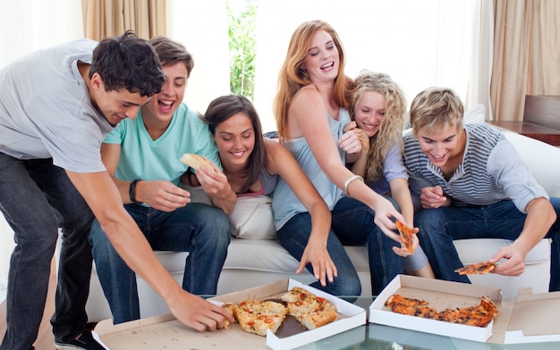 Amigos comendo pizza em casa