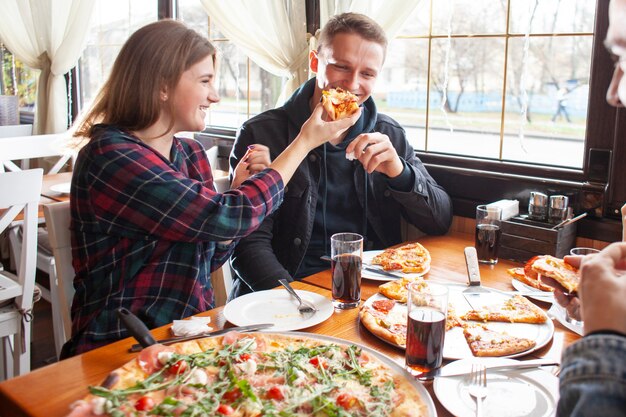Amigos, comendo pizza, junto