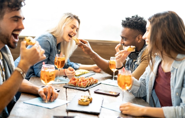 Foto amigos comiendo y bebiendo spritz en el restaurante bar de cócteles de moda