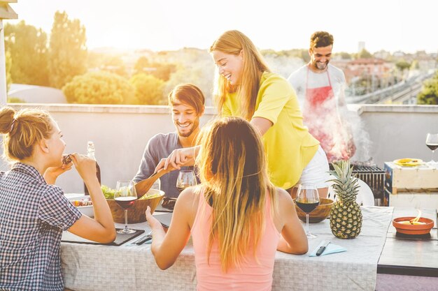 Amigos comiendo y bebiendo en la terraza de la construcción