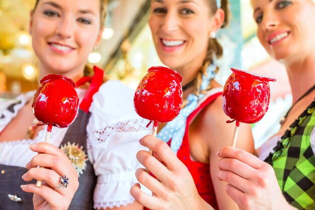 Amigos comiendo manzanas de caramelo en el Oktoberfest