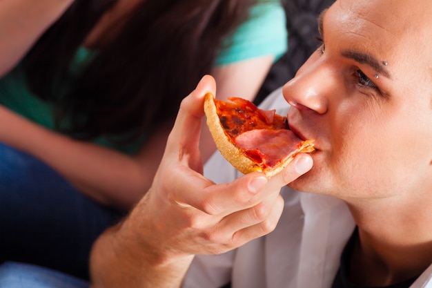 Amigos comiendo pizza en casa