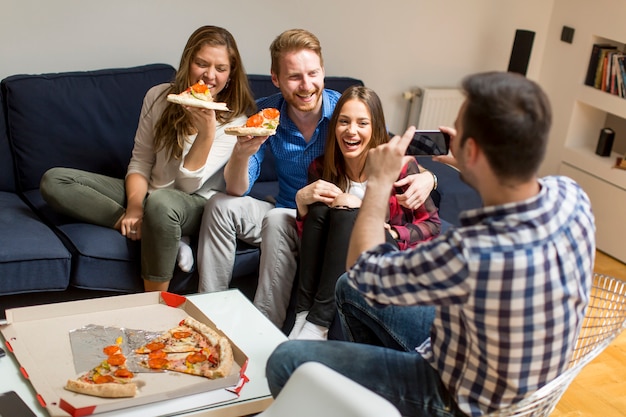 Foto amigos comiendo pizza juntos en casa