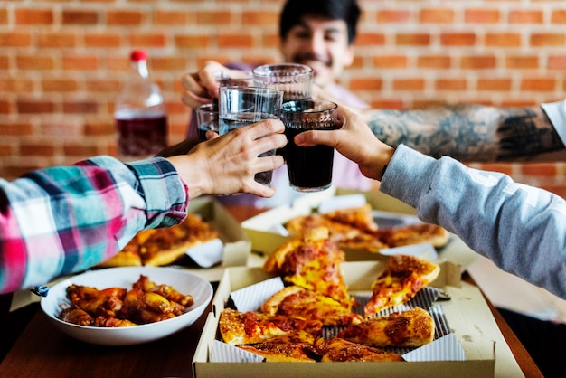 Foto amigos comiendo pizza juntos en casa