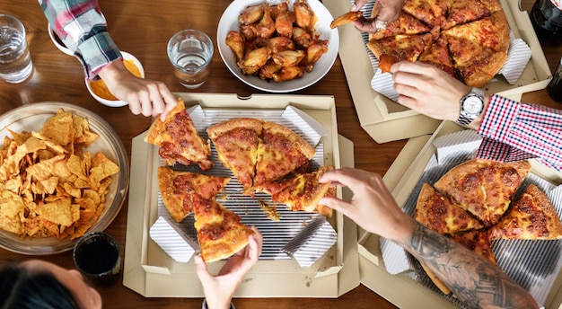 Amigos comiendo pizza juntos en casa