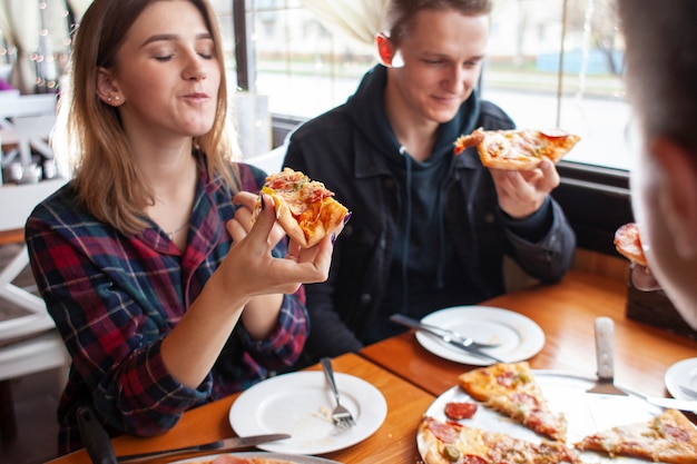 Amigos comiendo pizza juntos