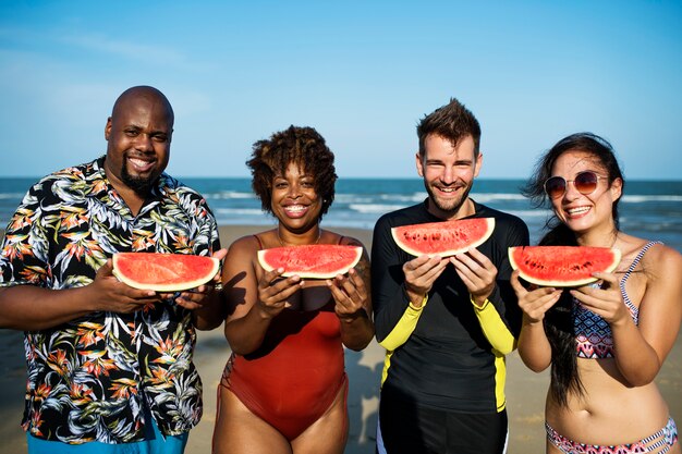 Amigos comiendo sandía en la playa