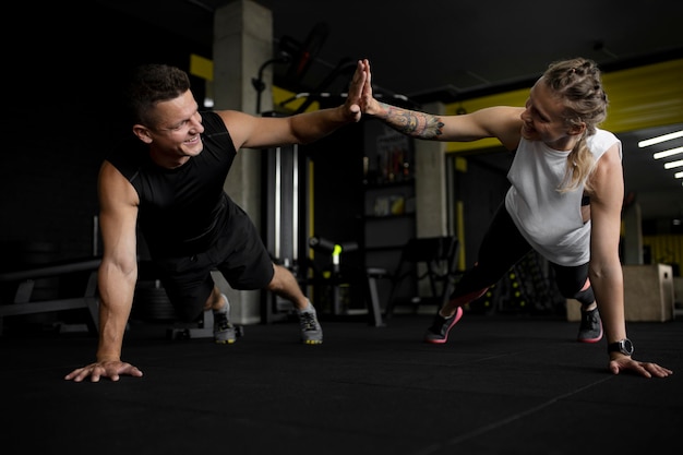 Foto amigos completos treinando na academia