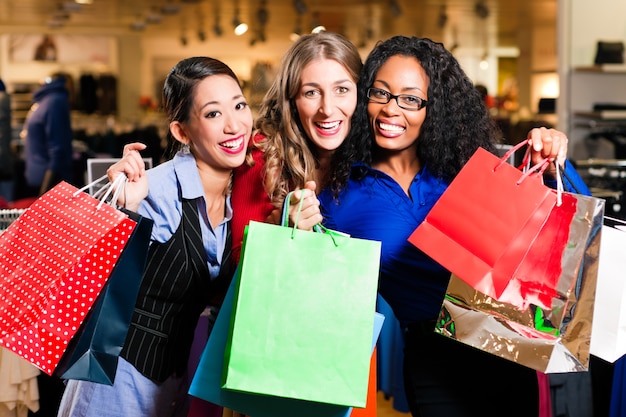 Amigos de compras con regalos en el centro comercial