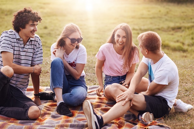 Amigos, conceito de felicidade e lazer. foto de adolescentes amigáveis se reúnem na natureza, fazem piquenique