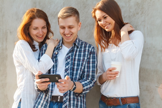 Amigos conversando ao ar livre e usando seus smartphones