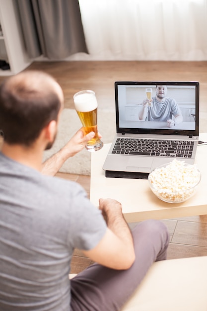 Amigos conversando na videochamada e bebendo cerveja durante o distanciamento social.