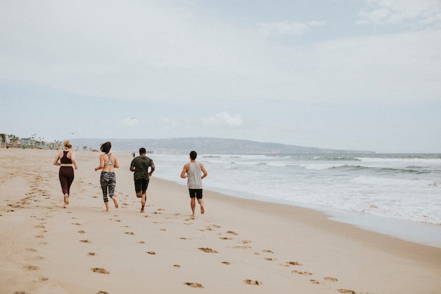 Amigos corriendo juntos en la playa