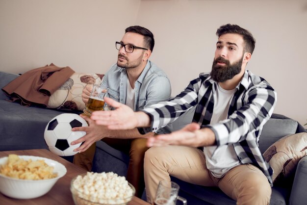 Amigos curtindo futebol na TV