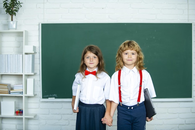 Amigos da escola, duas crianças, menina e menino de mãos dadas, indo para a aula na primeira classe