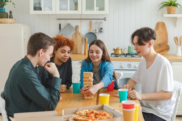 Amigos da festa em casa passando um tempo juntos jogando na torre de madeira do jogo de tabuleiro em casa feliz div