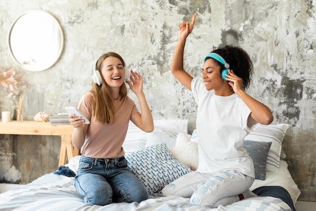 Amigos dançando na cama em casa