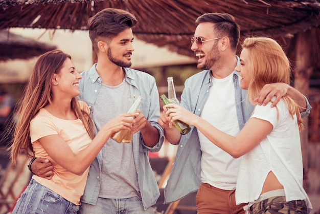 Amigos dançando na praia em dia ensolarado