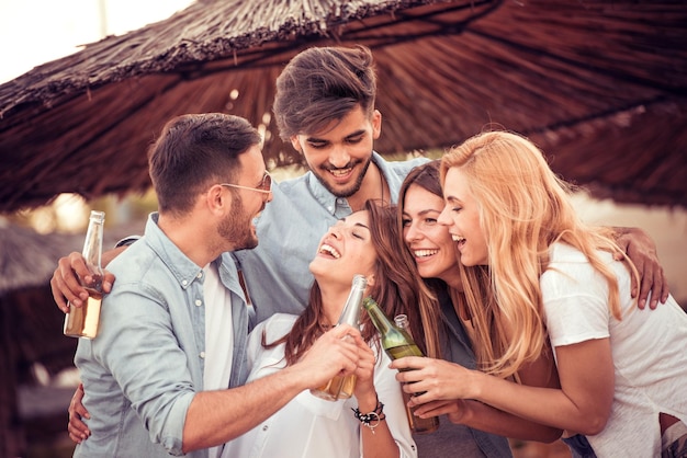 Amigos dançando na praia em dia ensolarado