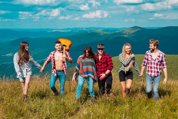 Amigos de acampamento em grupo em uma viagem de acampamento caminhando perto do lago com vista para o turista das montanhas