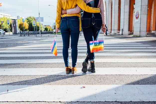 Amigos de duas mulheres saindo na cidade acenando LGBT na cidade de Madrid