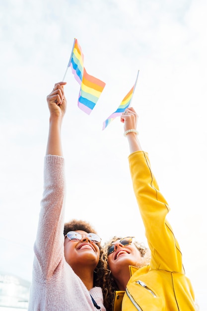 Amigos de duas mulheres saindo na cidade acenando LGBT