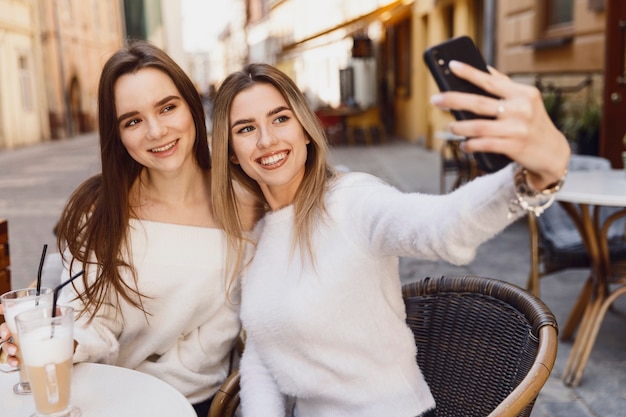 Amigos de garota tomando uma selfie em uma mesa de café