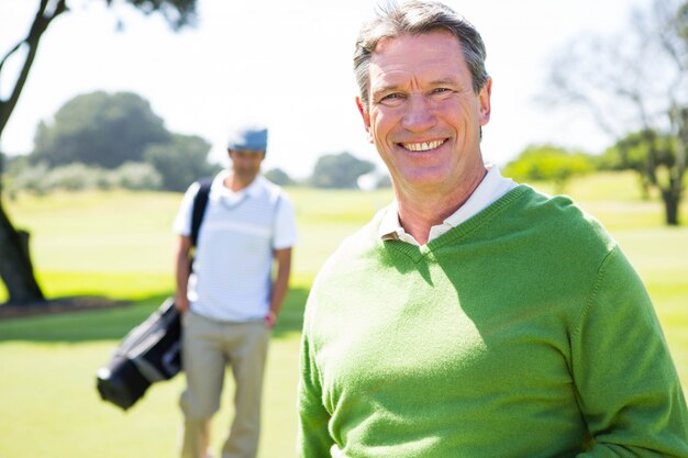 Amigos de golfe sorrindo na câmera