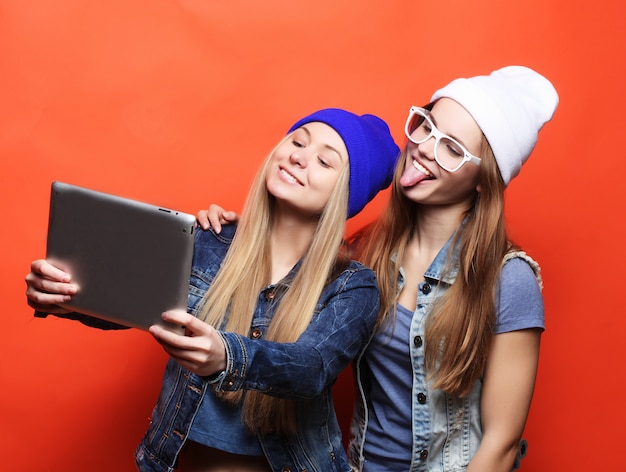 Amigos de menina hipster tomando selfie com tablet digital