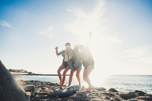 Amigos de pé na praia contra o céu