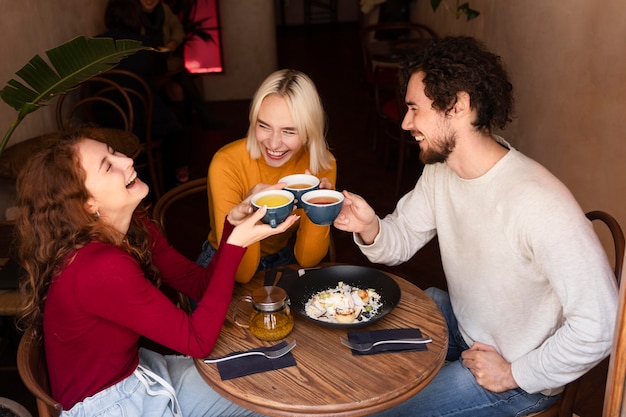 Foto amigos de tiro médio com xícaras de café