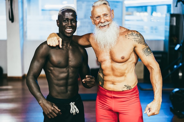 Amigos de várias gerações se divertindo após a rotina de exercícios na academia - concentre-se nos rostos