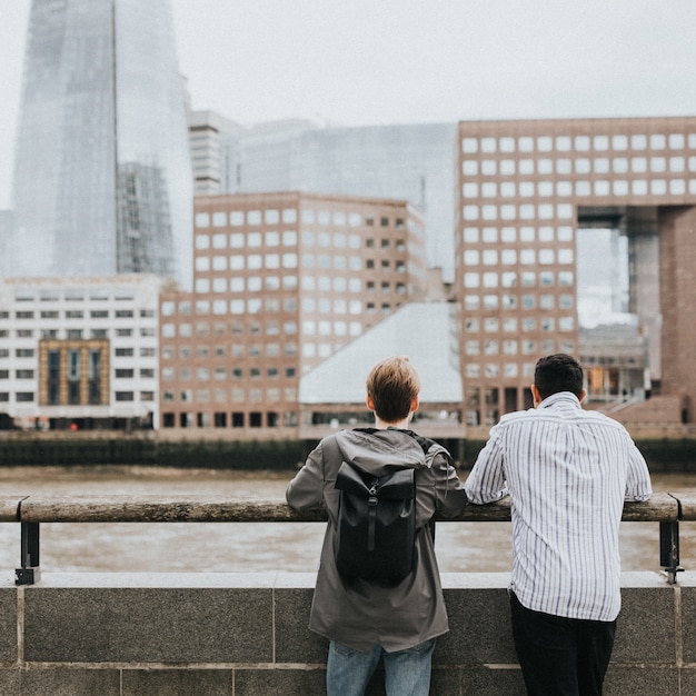 Amigos de viajantes admirando o horizonte de Londres de uma ponte