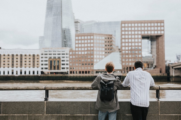 Amigos de viajantes admirando o horizonte de Londres de uma ponte