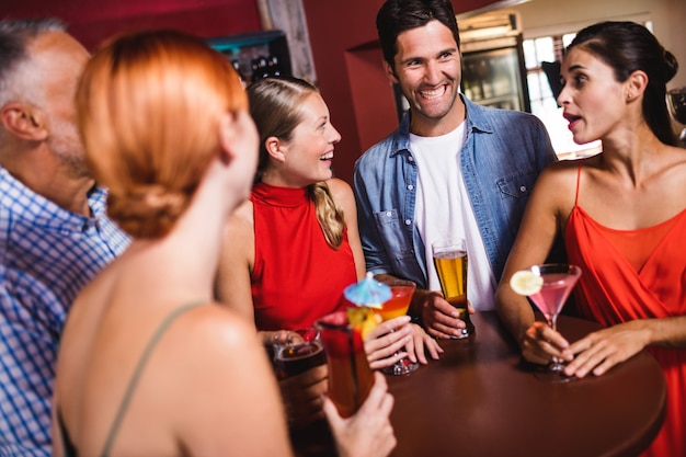 Amigos disfrutando de las bebidas en la mesa en la discoteca