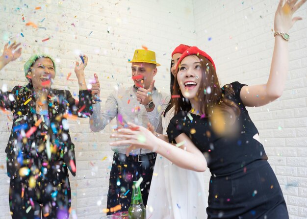 Foto amigos disfrutando de la fiesta contra la pared de ladrillo